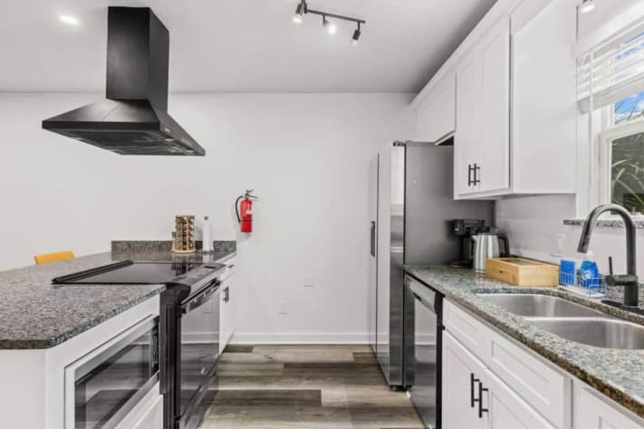 Unit A's spacious kitchen features a Samsung refrigerator, Sharp microwave, dishwasher, stove, and oven. A large island adds prep space, while cookware, bakeware, a food processor, blender, and toaster help you prepare meals throughout your stay