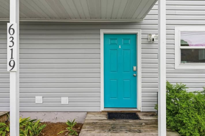 Unit A is the right-hand home when facing the duplex, with its own turquoise entrance and smart-lock self check-in. Your full-house booking includes both sides, each with a kitchen, lounge, laundry, and backyard, plus free on-site parking