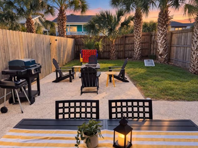 Unit A's fenced backyard has a covered dining patio, fire pit seating, electric BBQ, separate charcoal grill, cornhole, and giant four-in-a-row. Open the connecting gate to reach Unit B's yard and enjoy both outdoor spaces with your group