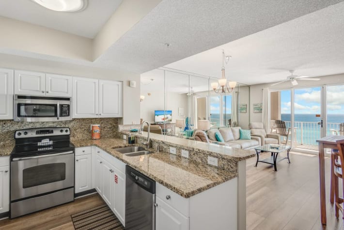The updated kitchen has granite countertops, stainless steel appliances, and is fully stocked with more than the basics