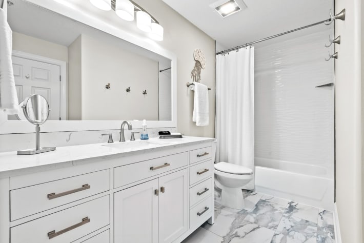 New flooring, new tile surround, new vanity, mirror and fixtures.