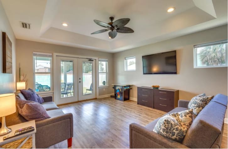 The great room features 2 arcade machines, 2 futons, and a smart TV