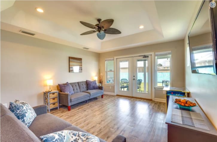 The great room features 2 arcade machines, 2 futons, and a smart TV