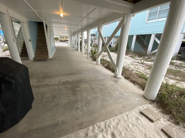Parking area beneath unit, stair access to unit, gas grill