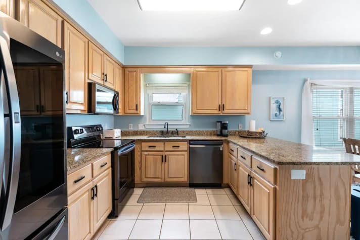 Kitchen area shows the sink, stove, oven and refrigerator