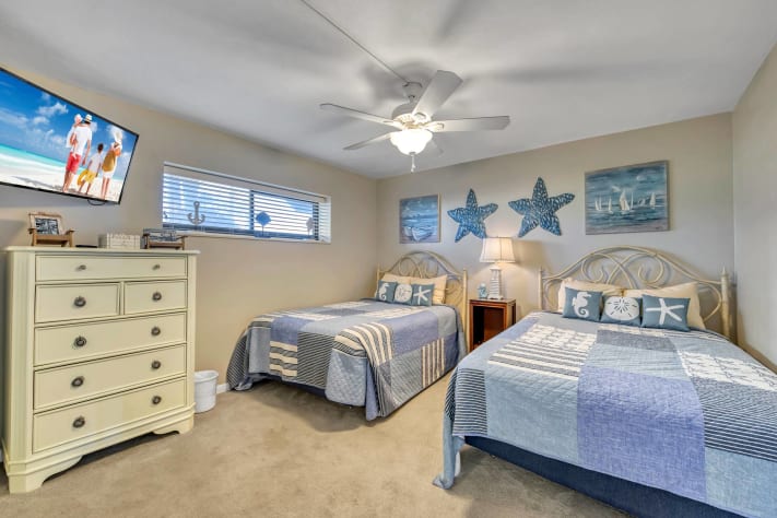 Guest bedroom with two full size beds and Roku tv.