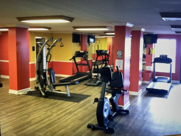 Workout room with lots of gym equipment and free weights.
