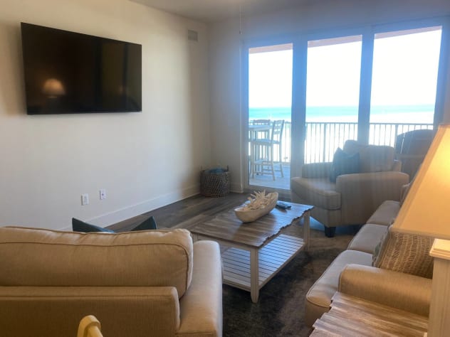 Living room with 65&rdquo; smart TV and beach view