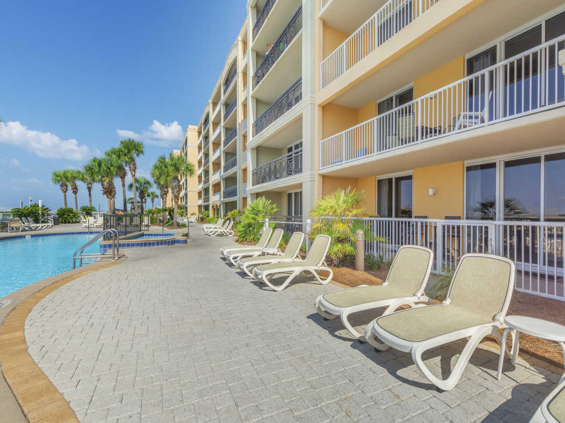 Chairs, hot tub, and seasonally heated pool outside of our unit (yellow one)