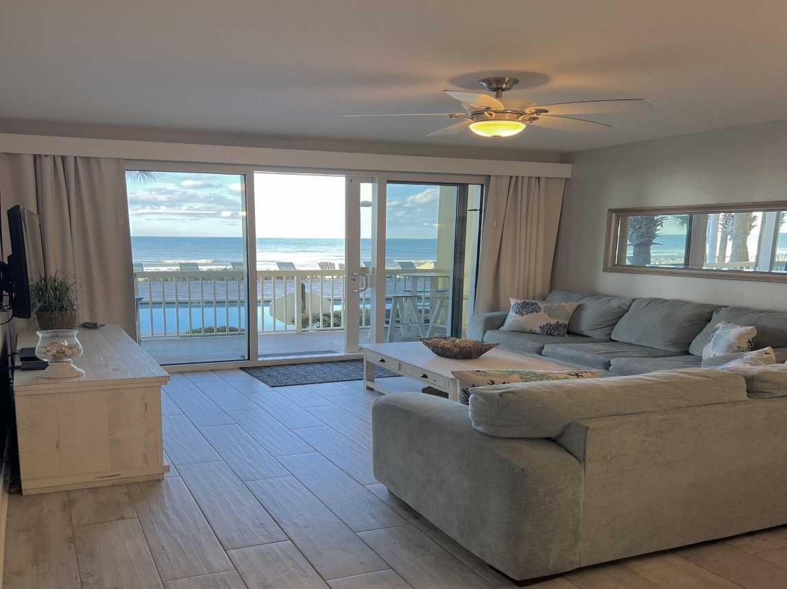 A beautifully updated living room with views of the Gulf with endless shades of blue stretching to the horizon.