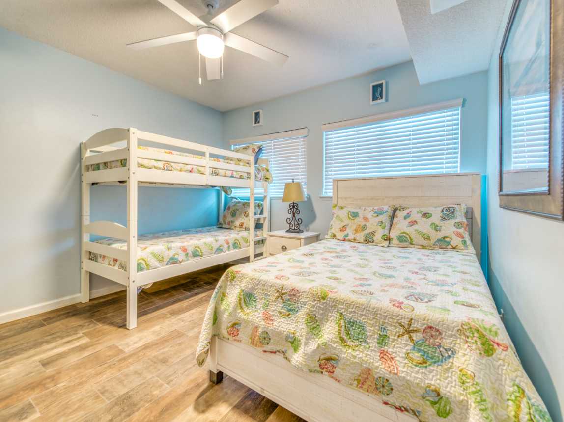 A cozy guest bedroom with a queen bed and bunk bed.