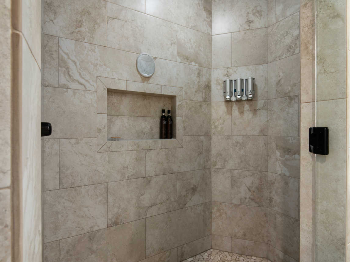 This unit's walk in master shower is a custom one, unique and luxurious