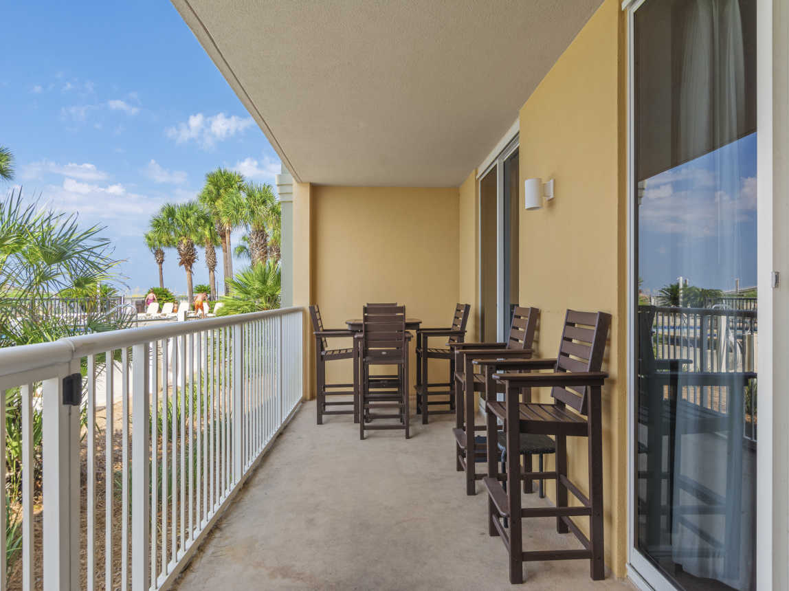 Patio with table and chairs, walks out to pools and boardwalk to beach