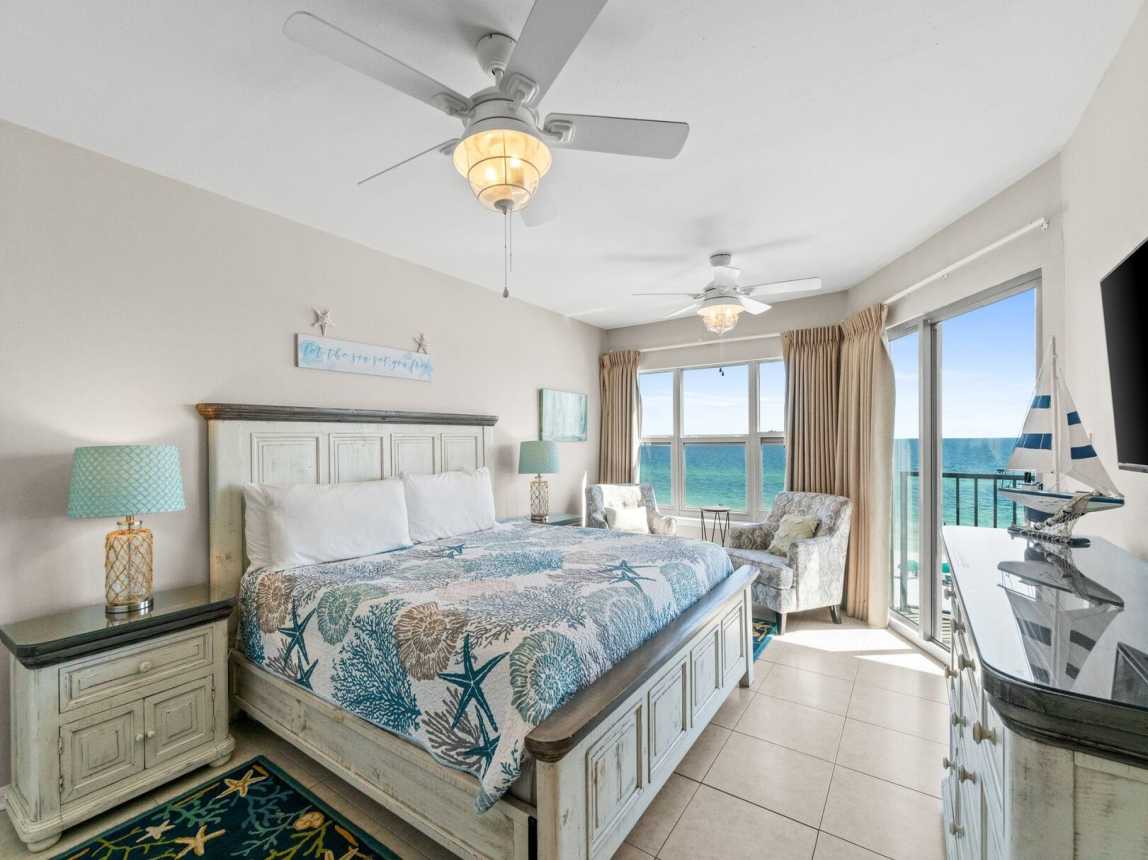 Master suite features a king-size bed, access to the balcony, and a private bathroom with a shower/tub combo.