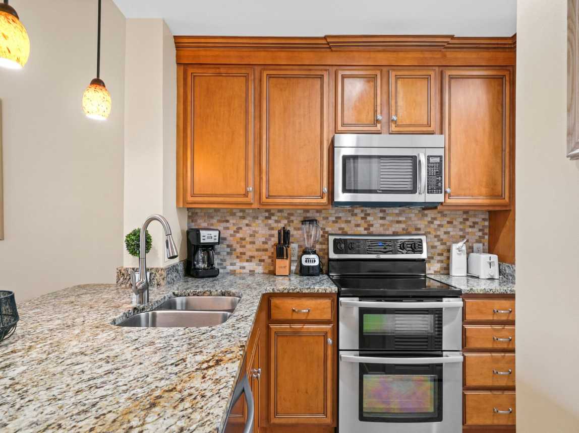 Granite counters with Double sink, disposal, microwave, coffee pot, blender, toaster, can opener and a double oven/range
