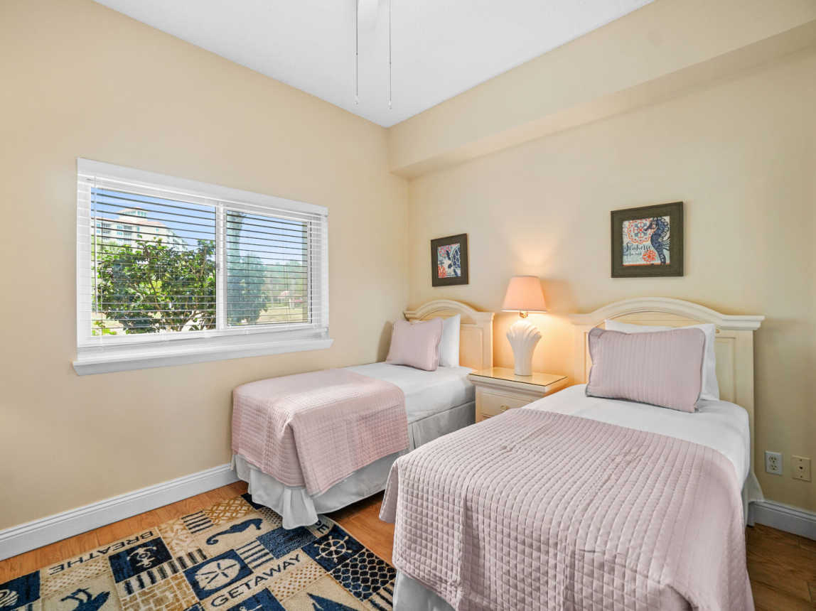 Guest room is very roomy with 2 twin beds and bedside table and lamp.