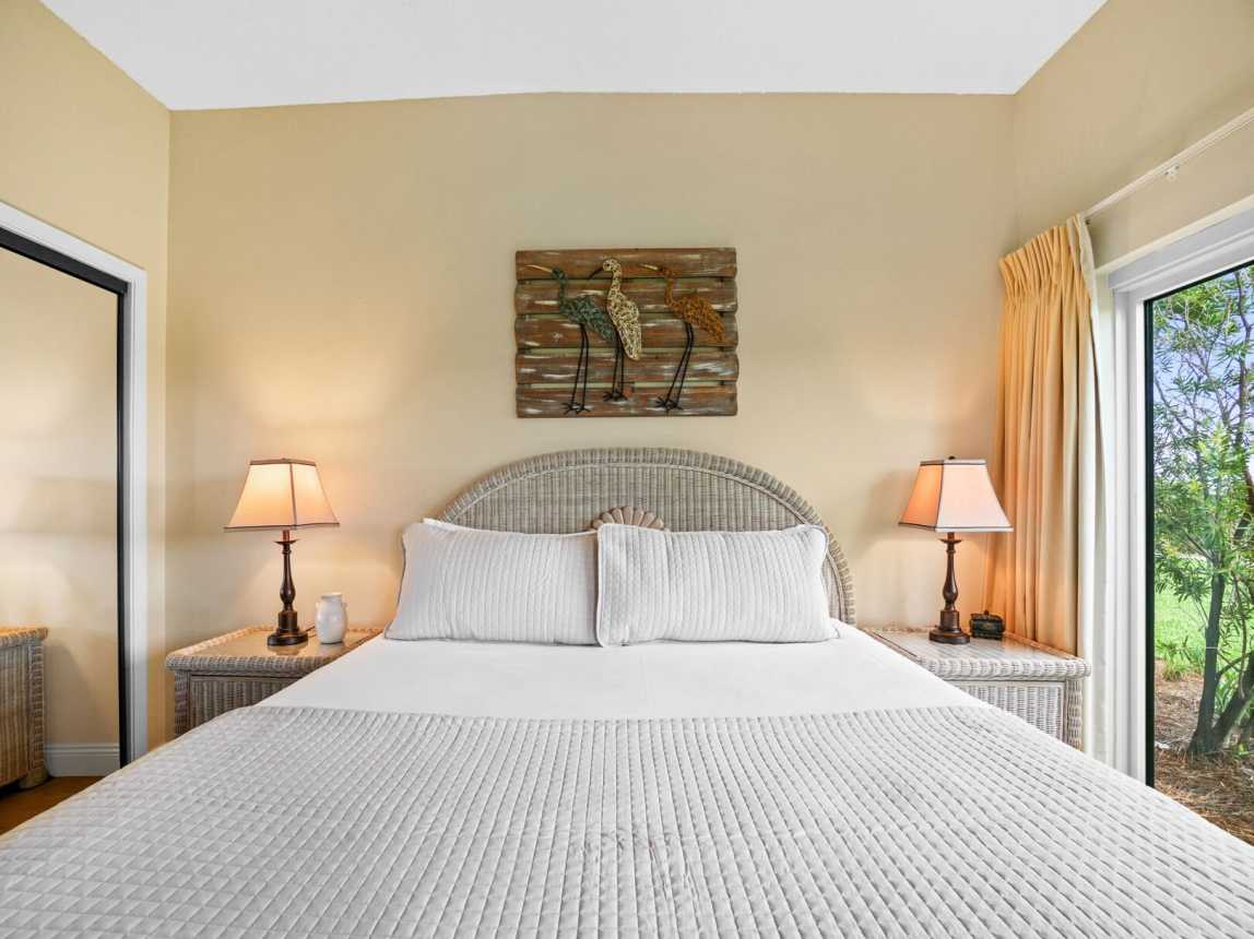 King bed flanked with bedside lighting and a little wildlife decor to make you feel like you are in the tropics.