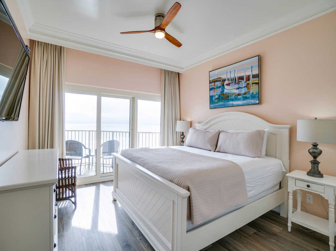 Master Suite comes with a king size bed, that offers a plush mattress, crisp linen and a light coverlet cover, all tastefully done with warm coral walls and ceiling to floor drapes for privacy. Easy access to your private balcony.
