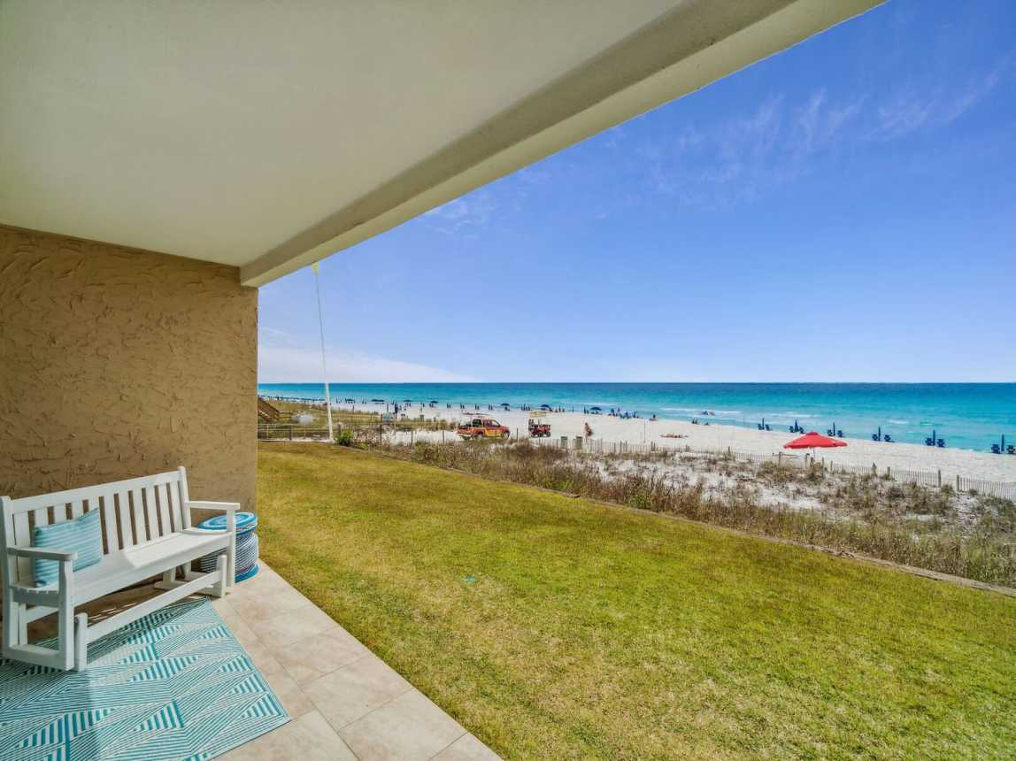 View of the patio, green area and boardwalk to the beach.