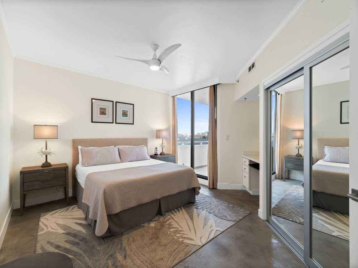 The second king bedroom suite is furnished with plush bedding, 2 side tables with lovely lighting, ceiling fan, double mirrored closet, small desk area and balcony access.