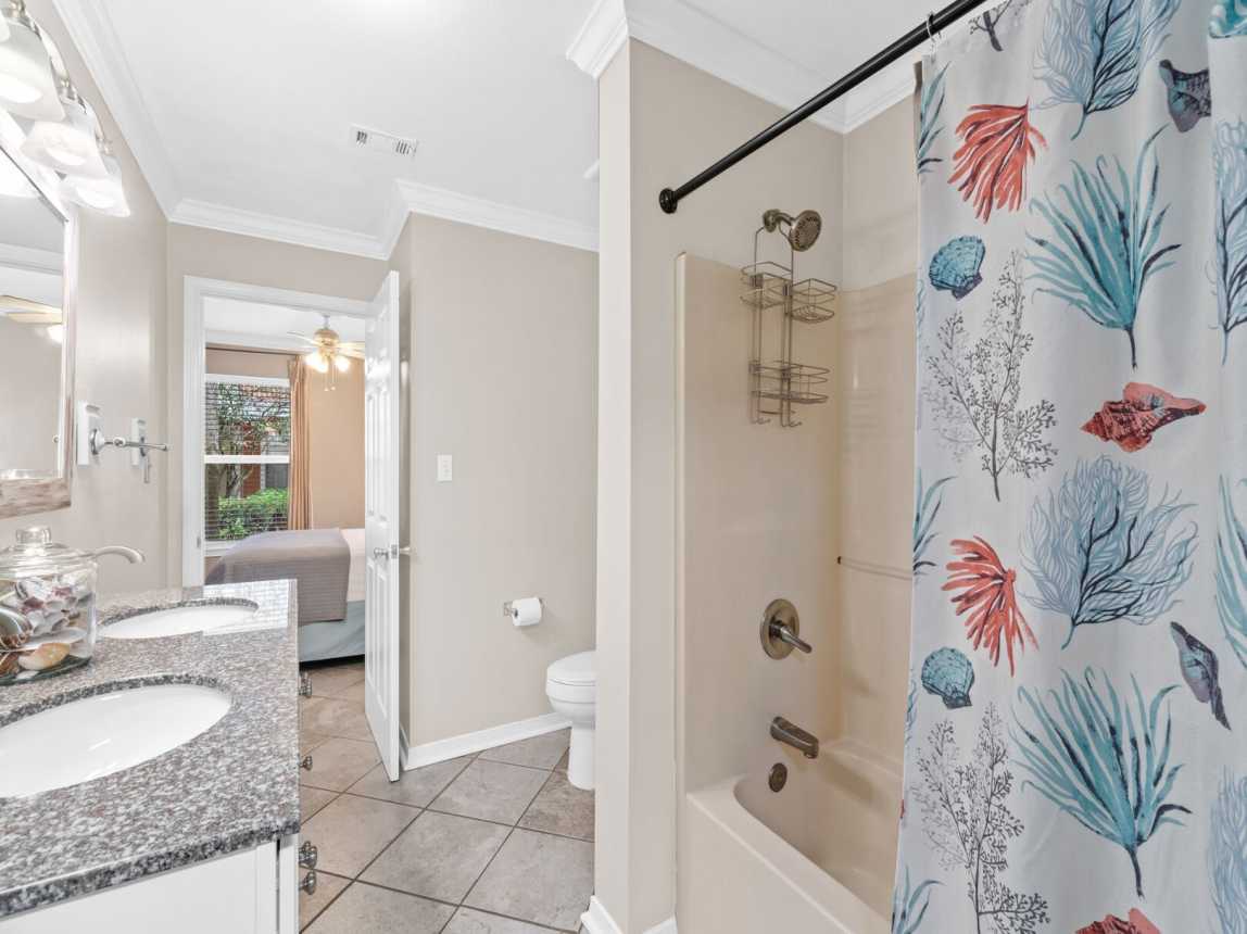 Bath showing double vanity, tub/shower combo and toilet area.