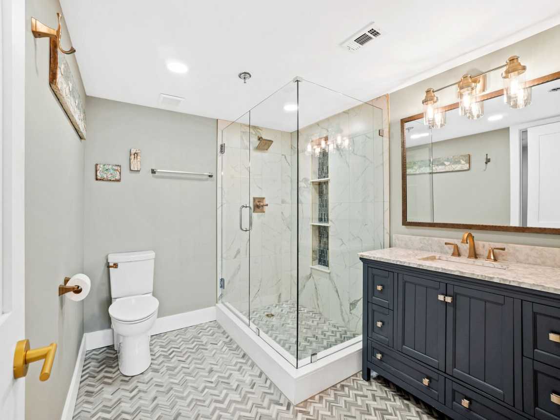 Well lit master bath with a large step in shower, single sink vanity cabinet and mirror for plenty of room to spread out. There is an closet just off the bathroom too.