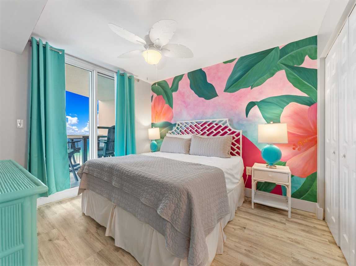 King bed in the master bedroom with plush furnishings and clean, crisp bedding. Plenty of light from the double sliding doors and lamps. Also has a celing fan for those warm summer nights.