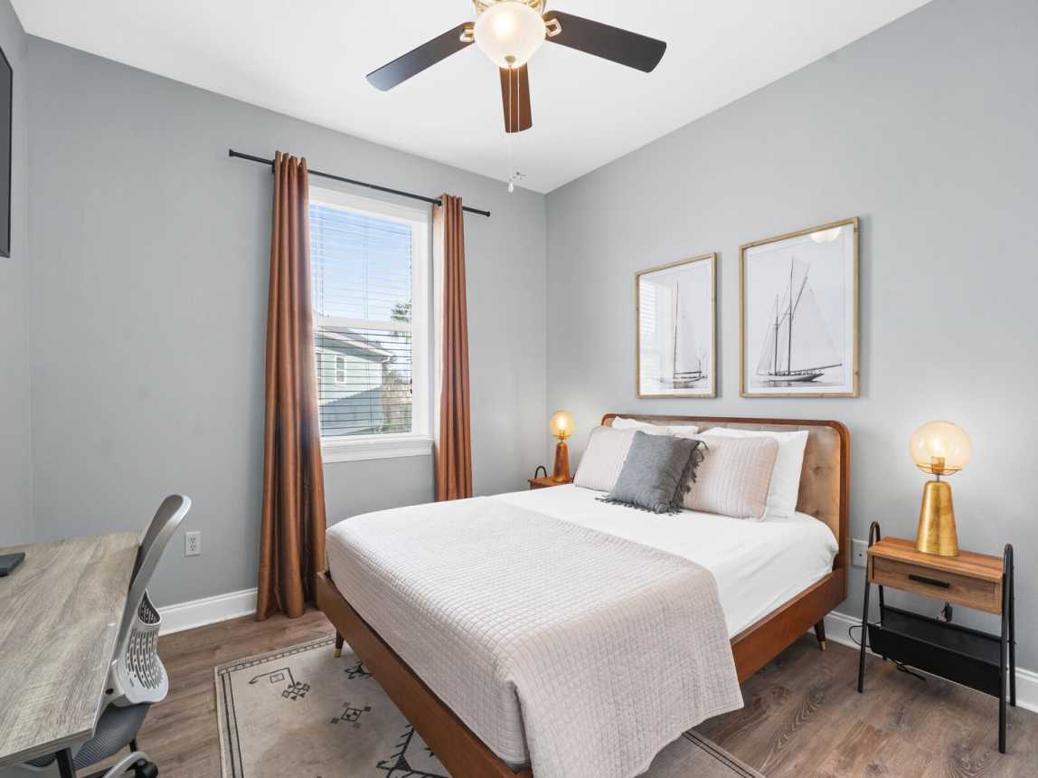 Great room with natural light, 2 night tables with ambient lighting and a small desk area.