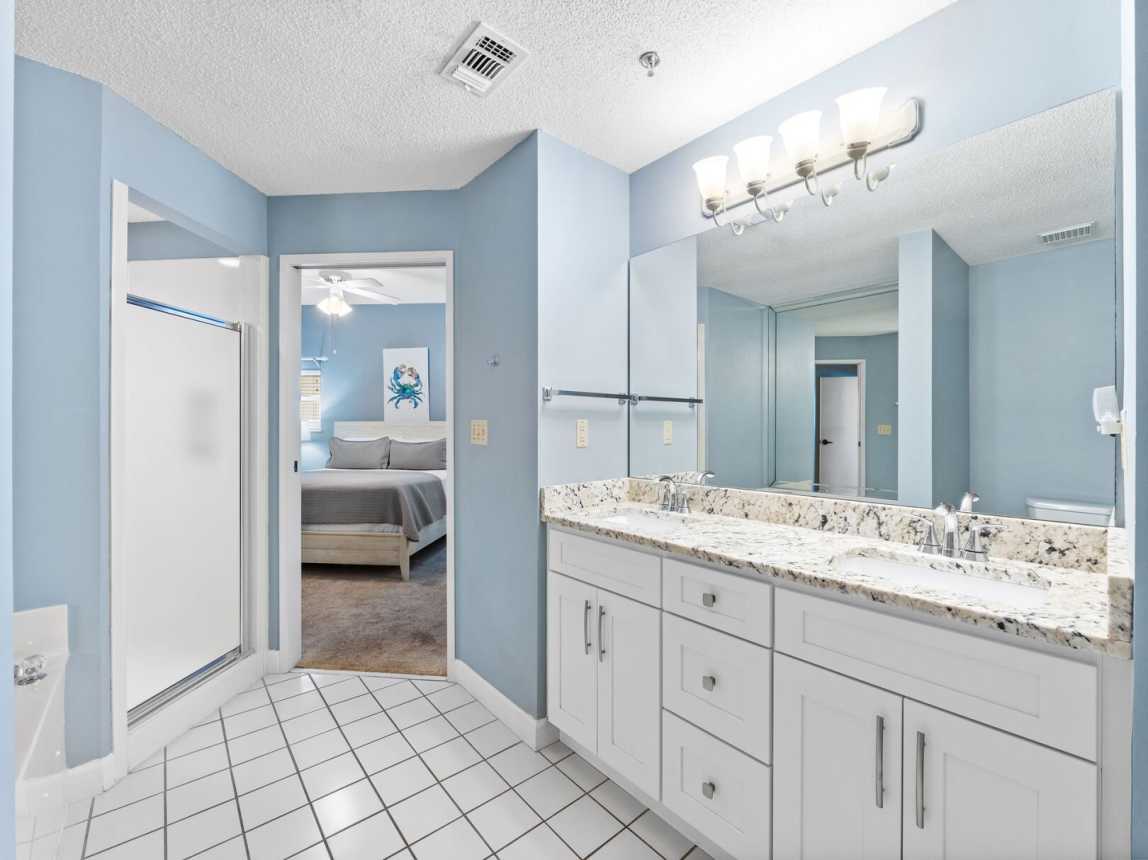 Master bath provides a walk in shower and a separate tub with a dual cabinet and full size mirror with plenty of warm but bright lighting. Great cabinet space provided for all your bath amenities including a hair dryer.