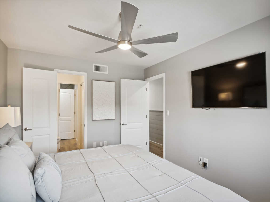 Bedroom with TV and separate vanity with door leading  in the bathroom that provides privacy