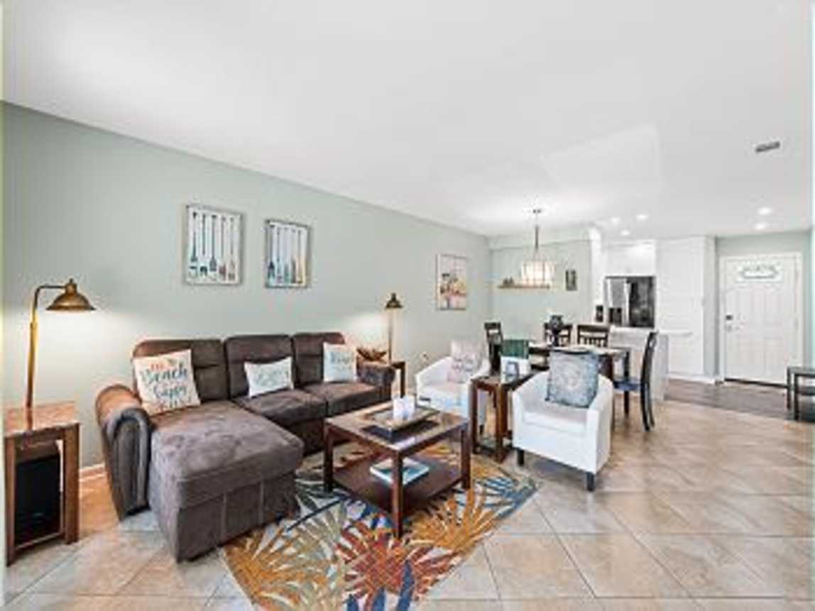 Open view of the living room, dining room and kitchen. Front entry into the property.