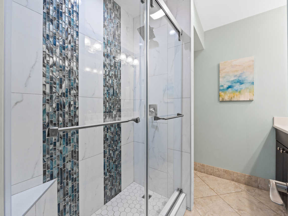 Brand new step in shower with a rain shower head and a convenient bench for all your bath ammenities.