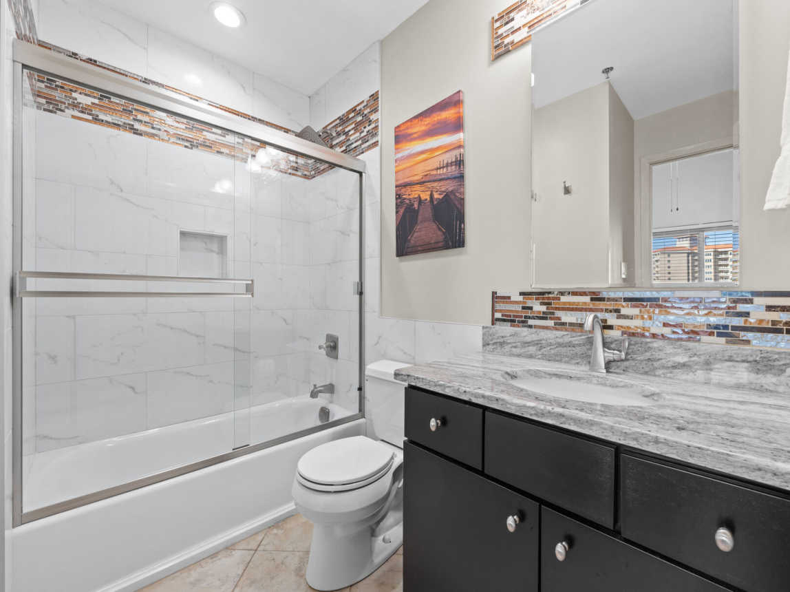 Complete remodel in the guest bathroom. Tub shower combo with sliding glass doors for an open spacious feeling while enjoying the rain style shower head. Single vanity sink, full size mirror and plenty of storage for your personal items.