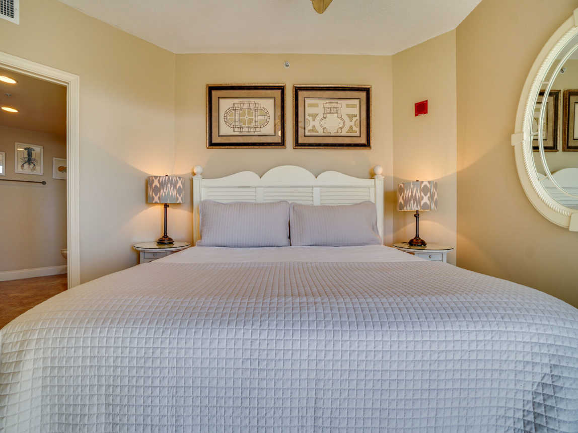 King Bed with crisp while linen with bedside tables and lamps.