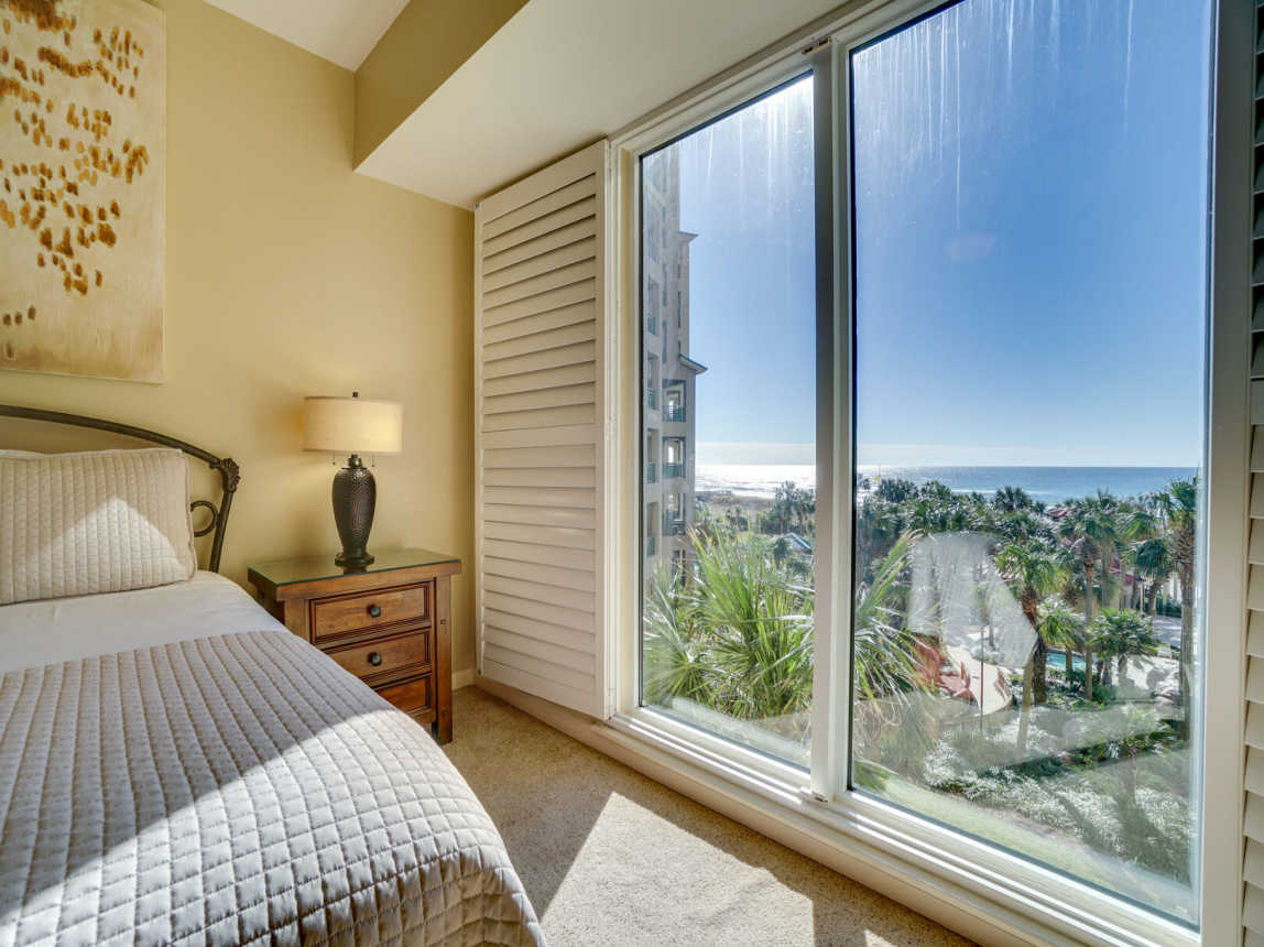Guest room has picturesque windows looking over the beautiful gardens of the resort with the pool in the background.
