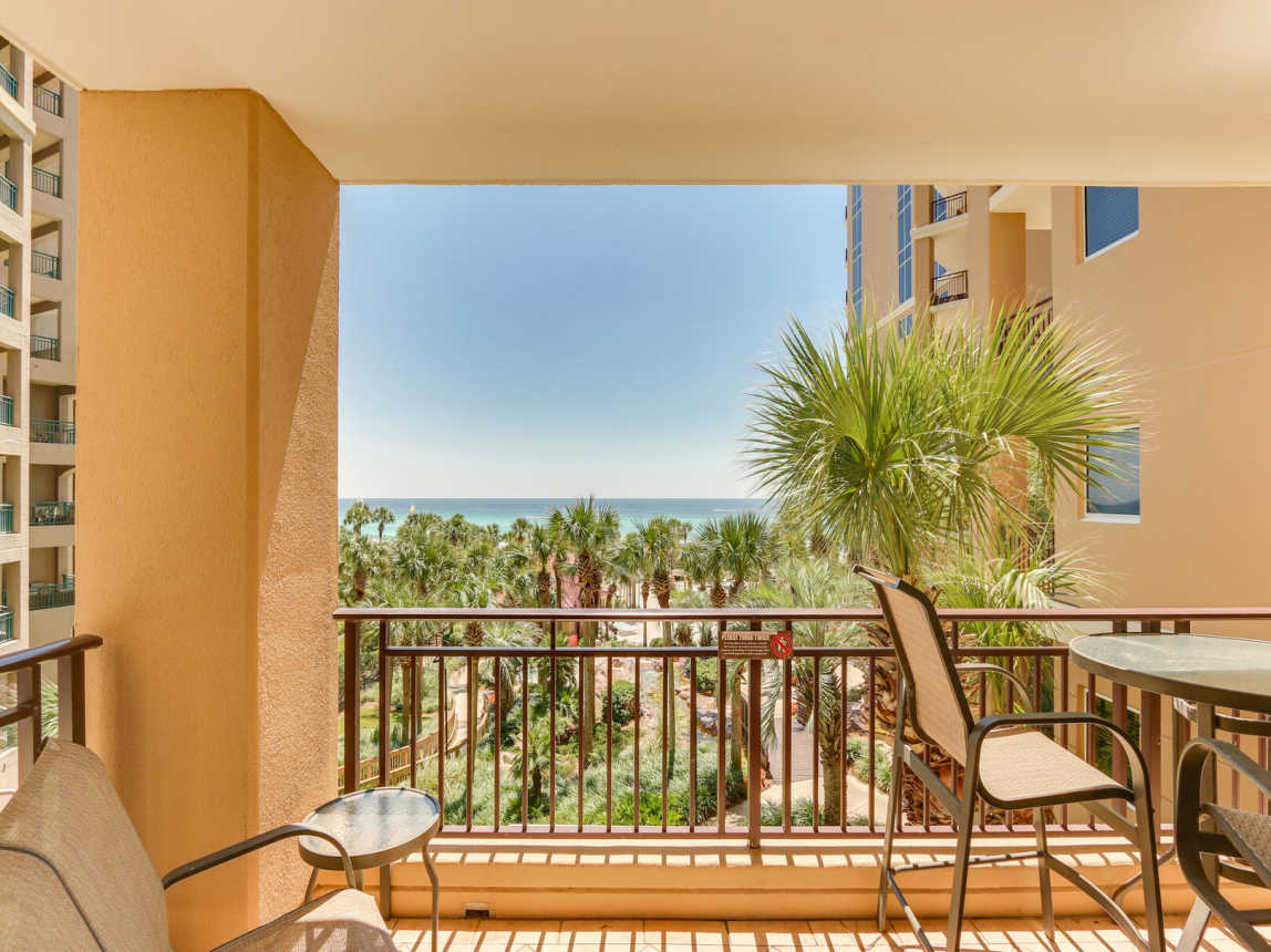 Balcony off the living room and Master Bedroom offer table for 4 high top table and chair and small side table. It overlooks the beautiful gardens and pool area.