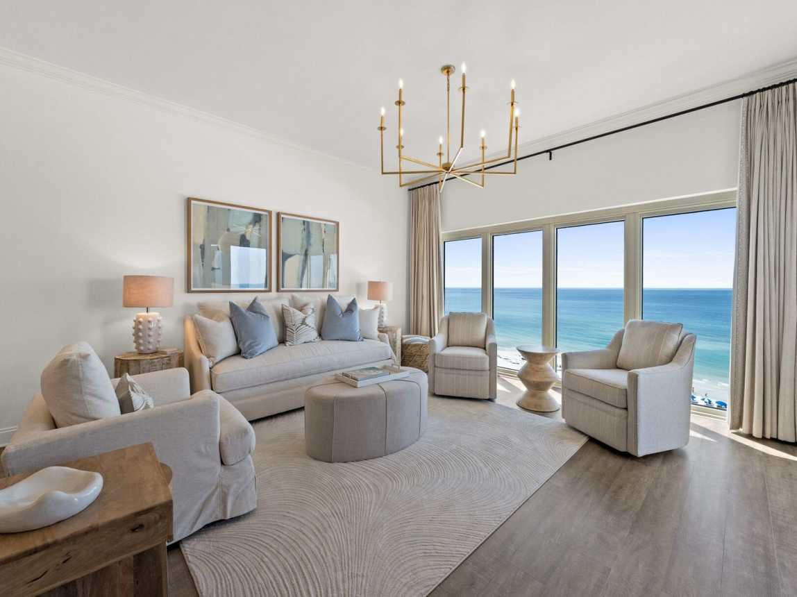 Spacious living room with a TV and stunning panoramic views of the Emerald Coast over Miramar Beach.