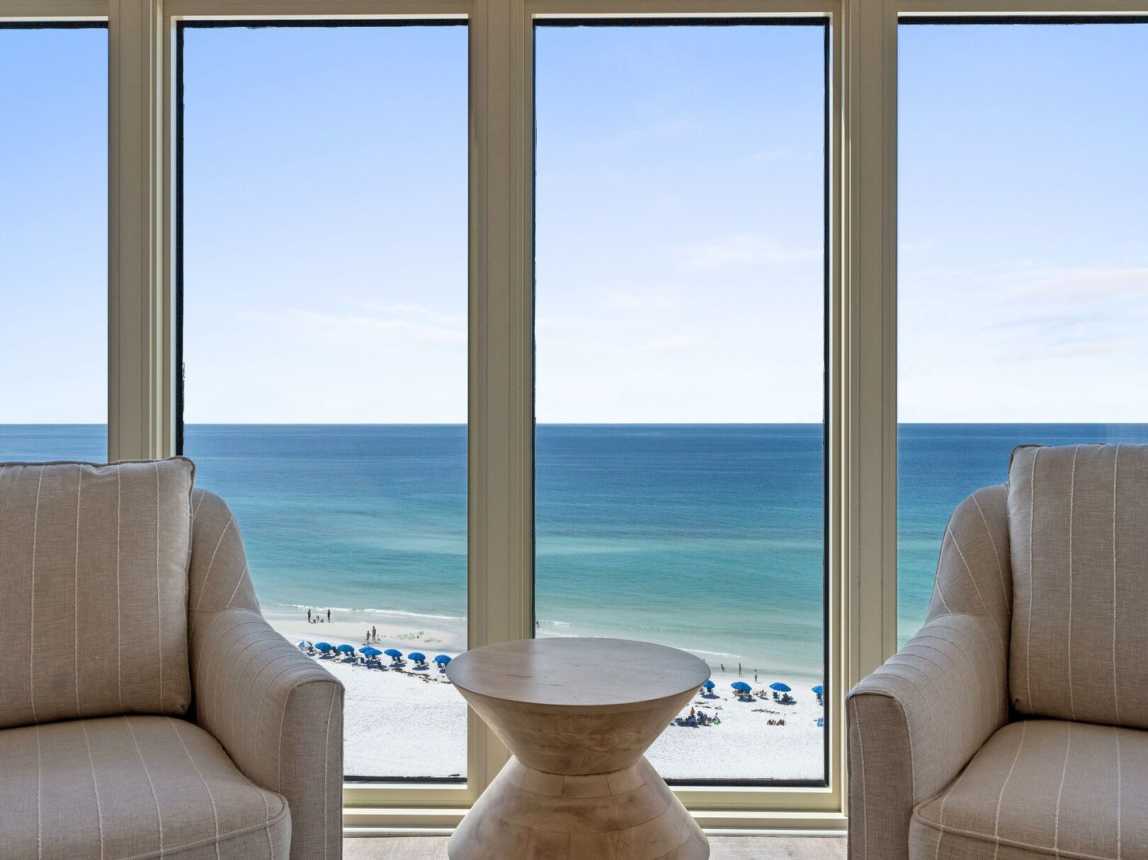 Spacious living room with a TV and stunning panoramic views of the Emerald Coast over Miramar Beach.
