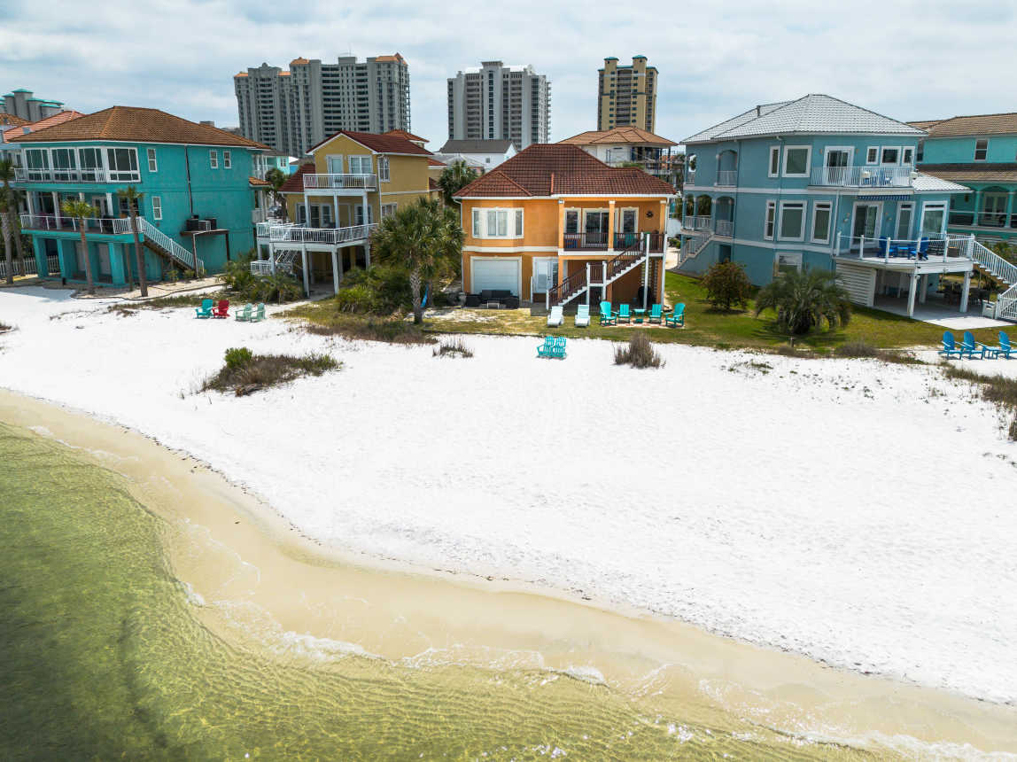 Back facade of the home with private sand beach