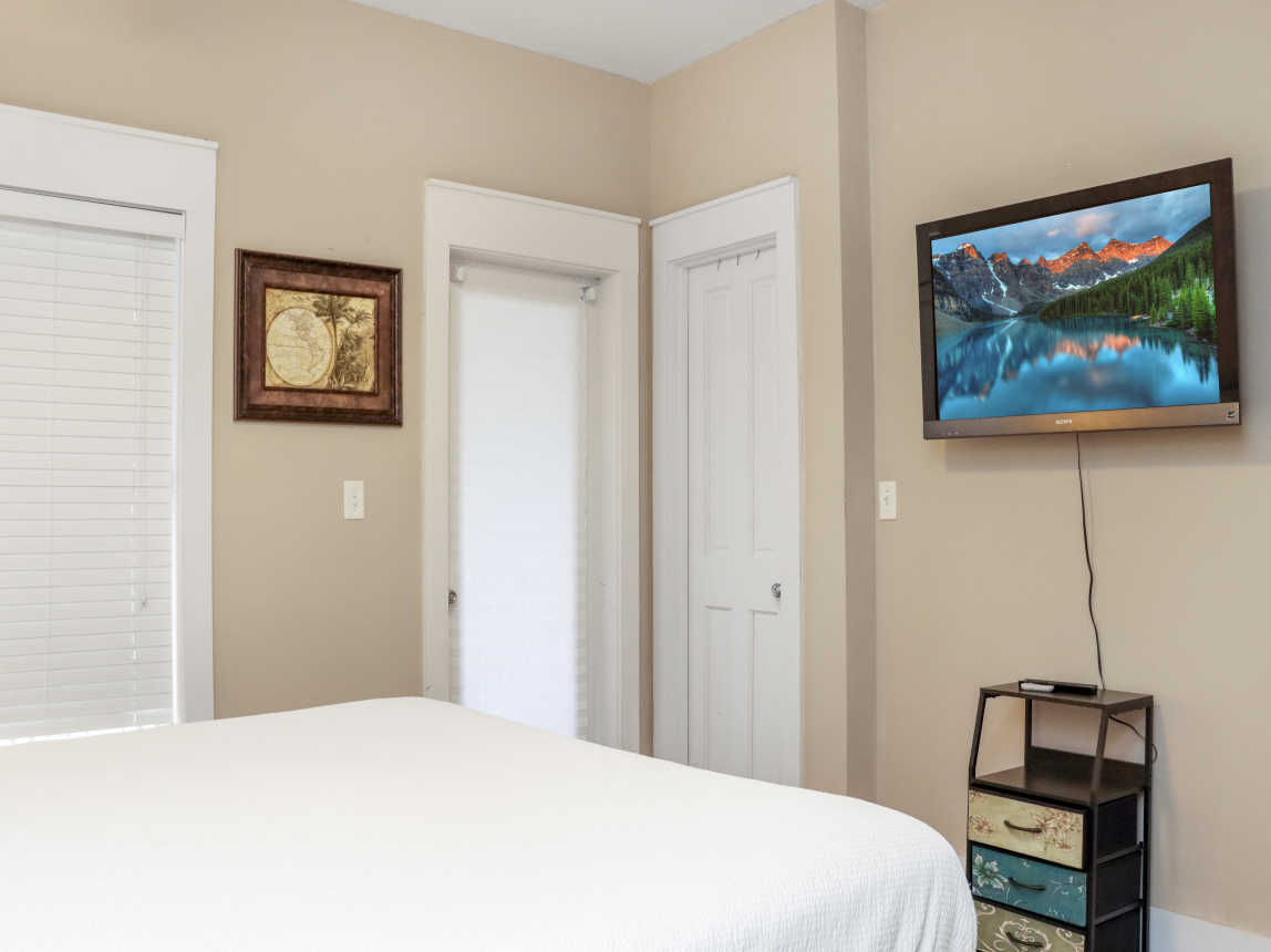 Bedroom 1 with TV and Screened Deck Access