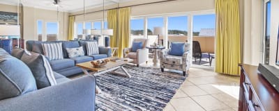Blues and yellows make this living room come to life with the feel of the beach. Large area for everyone to have a place to sit and relax.