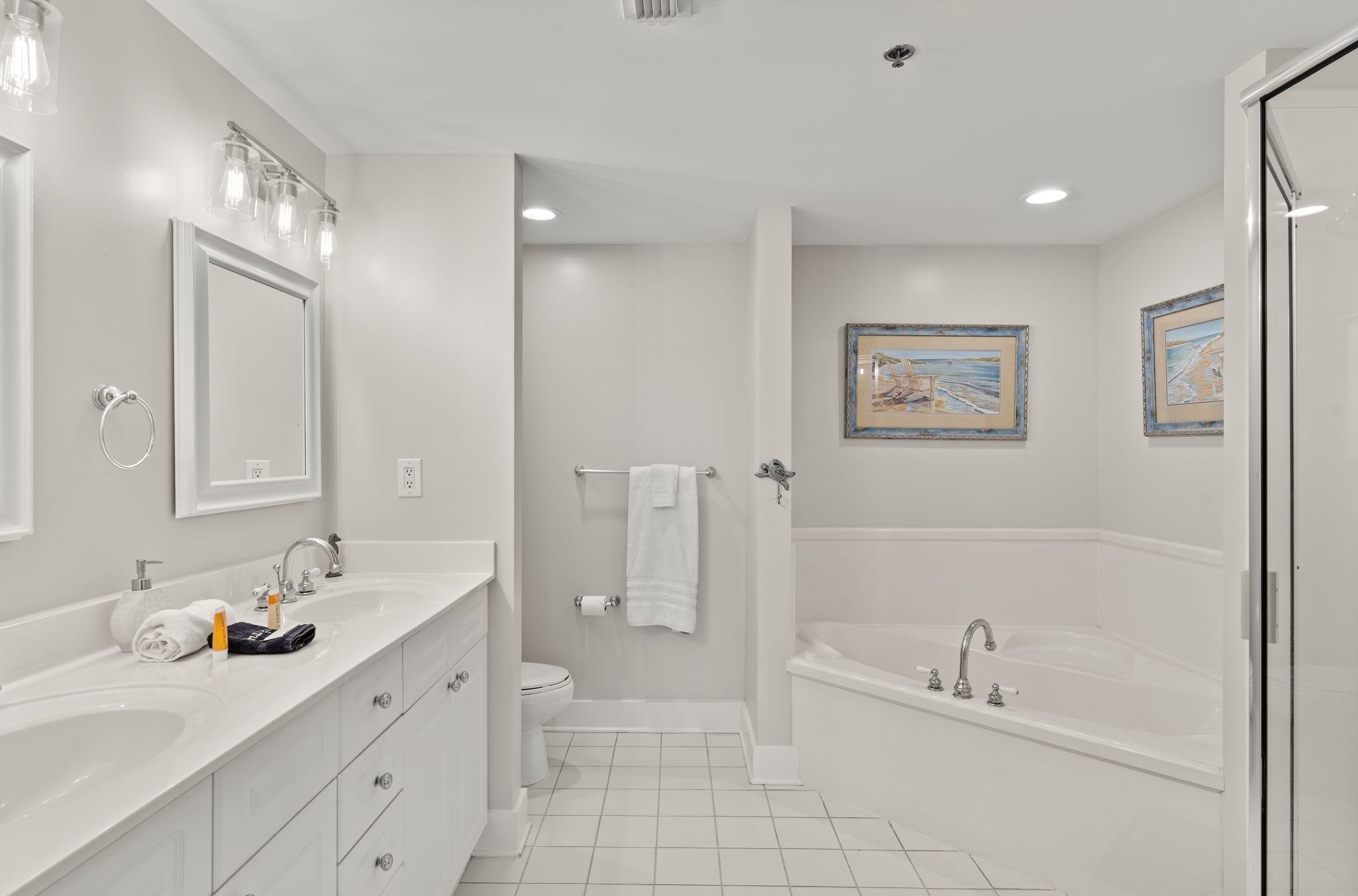 Master bathroom with double sink, tub, and large walk in shower 