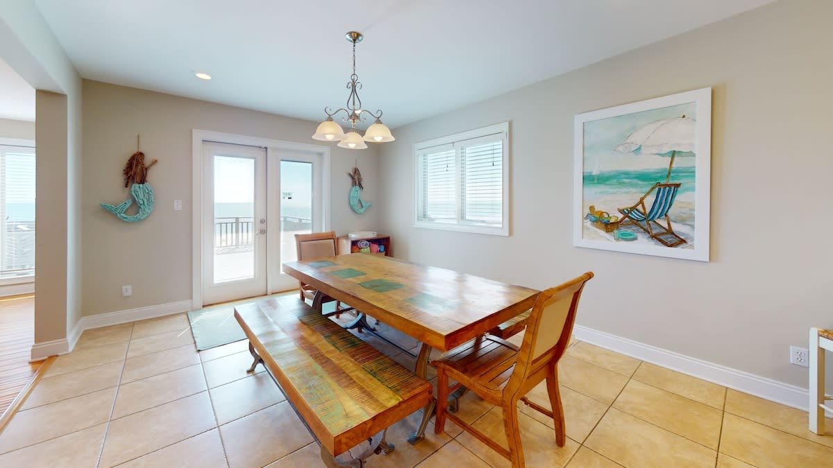 Dining area with doors to beach facing deck