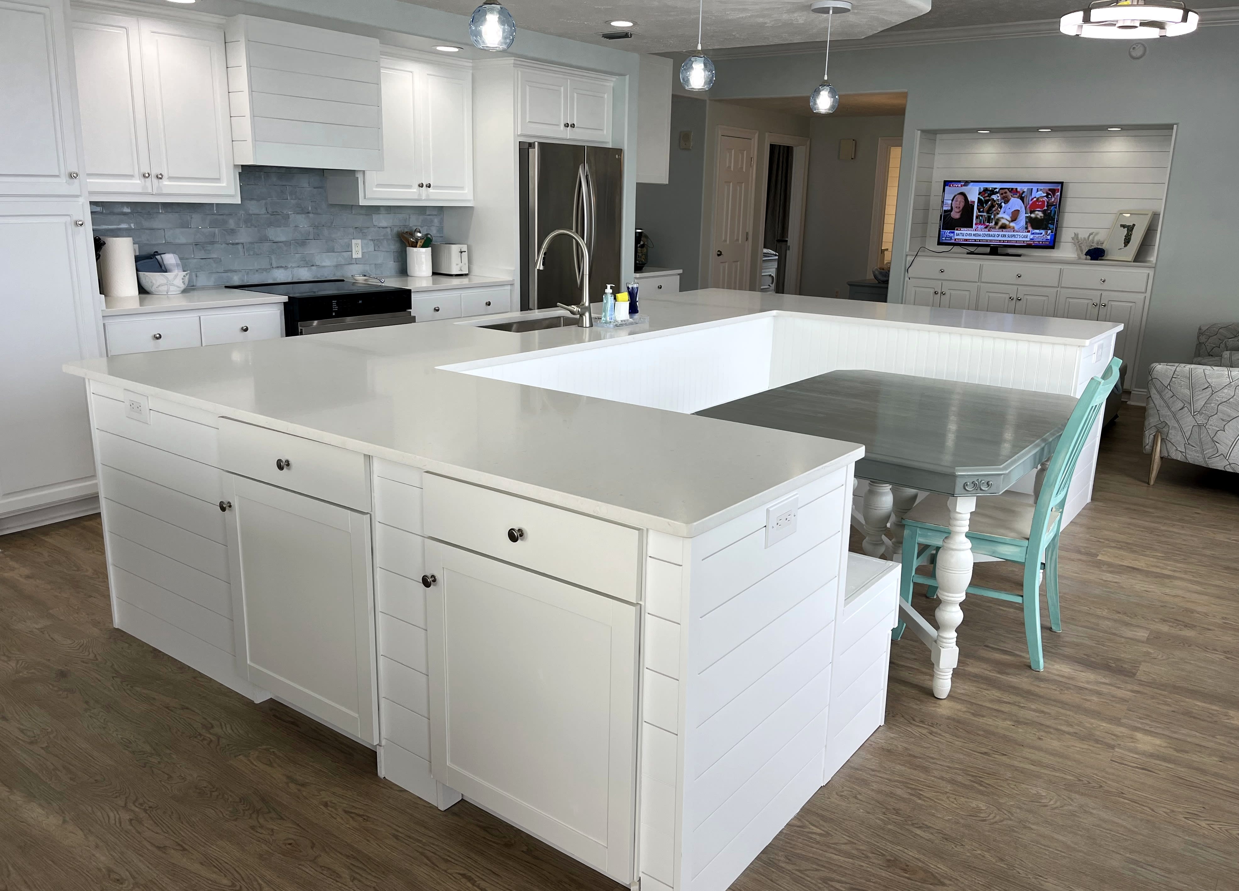 Newly renovated large open kitchen has a u-shaped island w large farmhouse sink