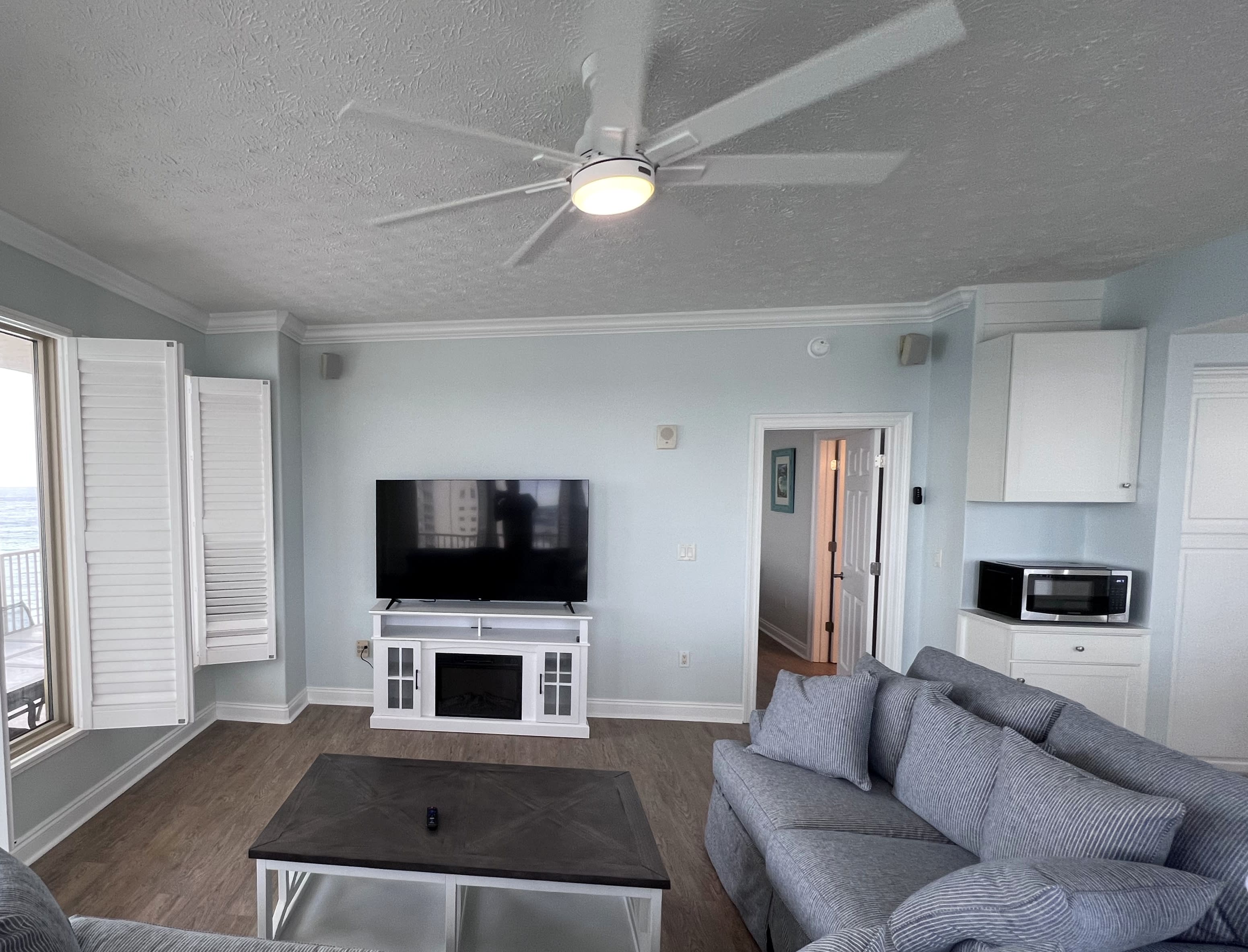 New living room furniture &amp; 65" TV on fireplace overlooking the Gulf
