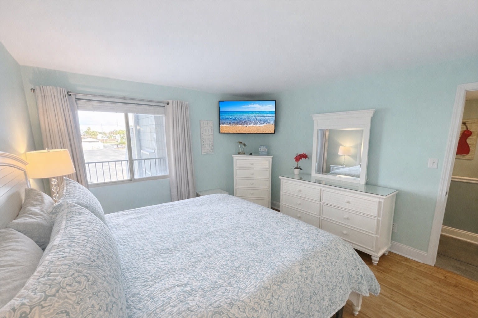 Spacious primary bedroom with KING BED and soft coastal tones and decor. 