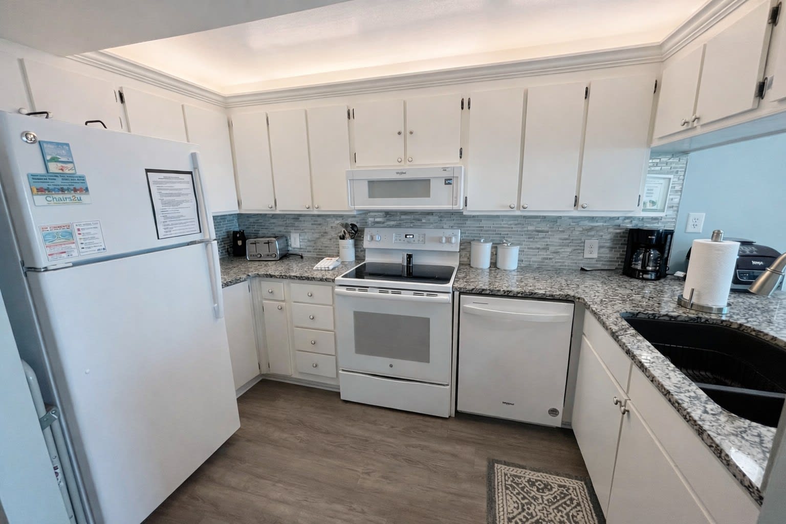 Well lit kitchen area with new appliances.