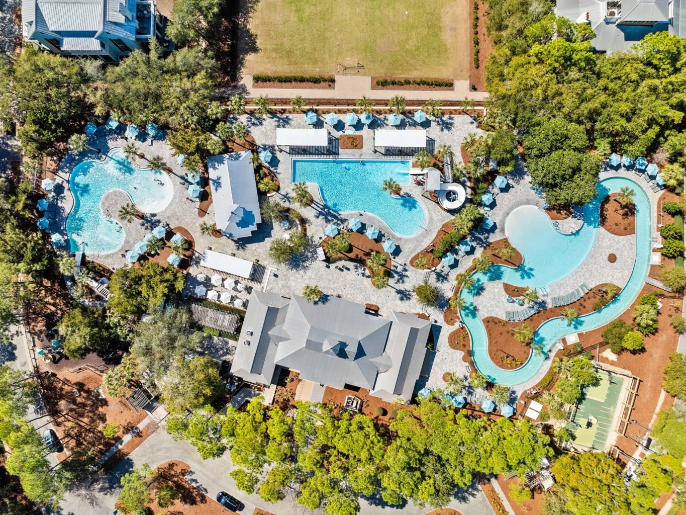 Aerial view of the resort-style pool area w/ winding pools, loungers & landscaped paths. Aerial view of the resort-style pool area w/ winding pools, loungers & landscaped paths.