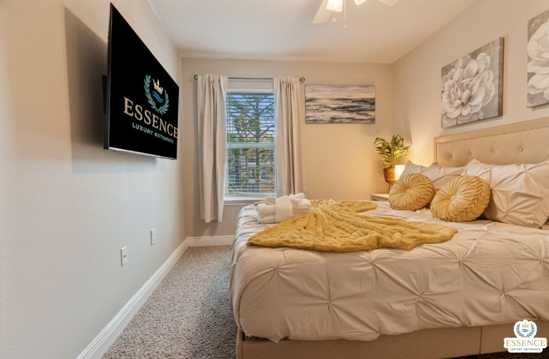 Cozy, beautifully styled bedroom with a plush bed, soft linens, and calming d&eacute;cor. Enjoy natural light, a wall-mounted TV, and a peaceful atmosphere perfect for relaxing and recharging after a fun day out.