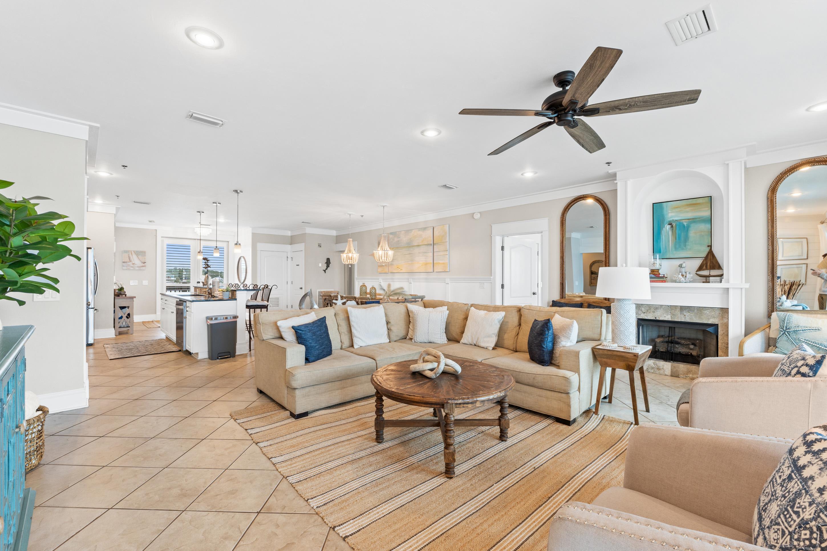 Relax in an elegant coastal living room featuring designer furnishings, expansive windows, and Gulf views. A perfect blend of comfort and style, designed for families who want more than just a rental.